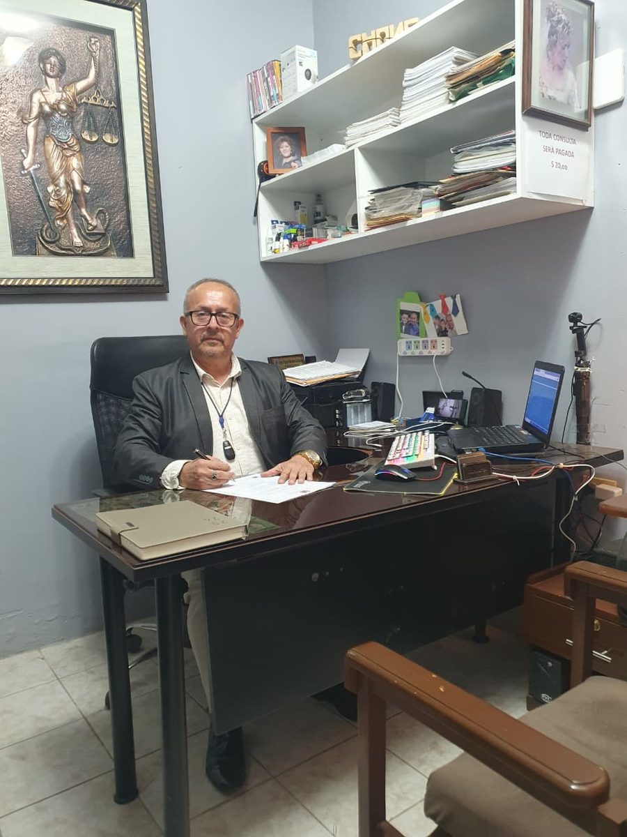 Ab. Olger Mendoza firmando documentos legales en su oficina